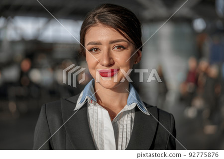 Smiling beautiful air hostess posing at camera 92775876