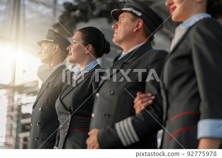Pilots and stewardesses standing in a row at the airport Pilots and stewardesses standing in a row at the airport 92775978