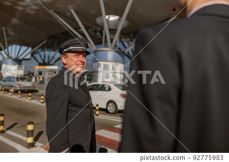 Two pilots talking near the terminal outdoor 92775983