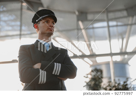 Serious adult male pilot looking away in the airport 92775997