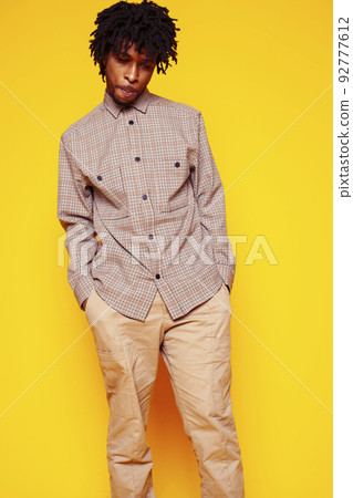 Young handsome african american guy student posing cheerful and gesturing on yellow background, lifestyle people concept close up 92777612