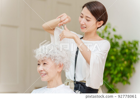 Hairdresser cutting hair of gray-haired woman Hairdresser cutting hair of gray-haired woman 92778061