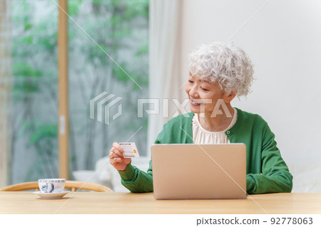 一個喜歡在電腦上網上購物的白髮女人 92778063