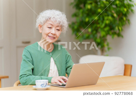 白髮女人在客廳裡使用電腦 92778068