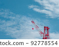 A red crane that shines in the refreshing blue sky 92778554