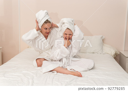 Daughter love bath smiling dries mom thinks elbows coffee bathrobe, concept portrait hygiene for dressing and happy beautiful, little bathing. Head health comfort, Daughter love bath smiling dries mom thinks elbows coffee bathrobe, concept portrait hygiene for dressing and happy beautiful, little bathing. Head health comfort, 92779285