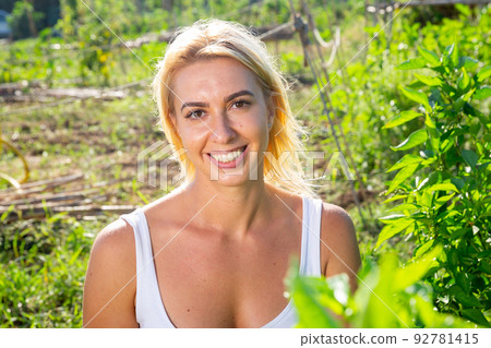 Attractive young blonde woman posing in home garden 92781415