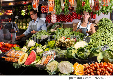 Two sellers working behind the counter Two sellers working behind the counter 92782282
