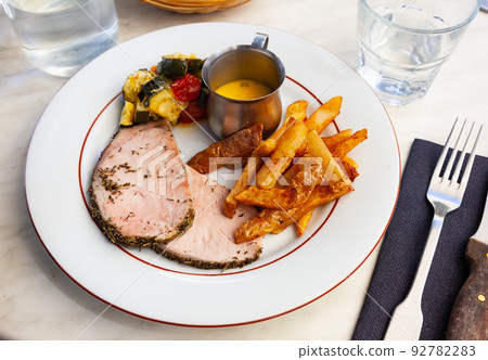 Pork loin with french fries and vegetables Pork loin with french fries and vegetables 92782283