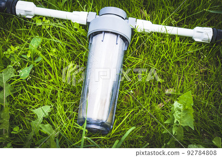 Water filter on green grass 92784808