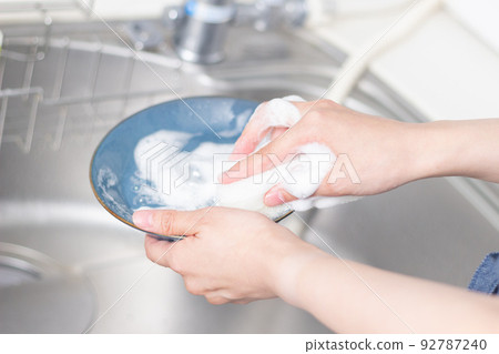 A woman washing dishes A woman washing dishes 92787240