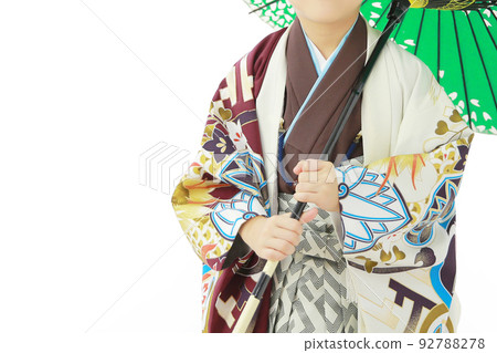 一個男孩穿著五顏六色的和服，拿著一把日本雨傘 92788278