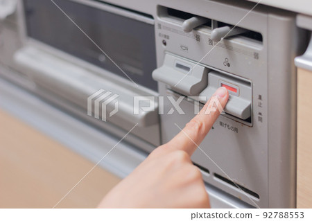 Woman pushing the switch on the gas stove 92788553