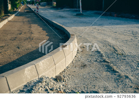 construction of road and sidewalk, close-up of a large curb construction of road and sidewalk, close-up of a large curb 92793636