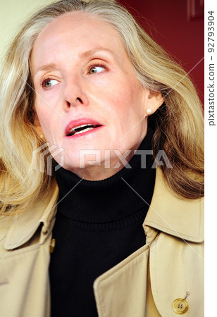 Female blond beauty expressions in a trenchcoat. 92793904
