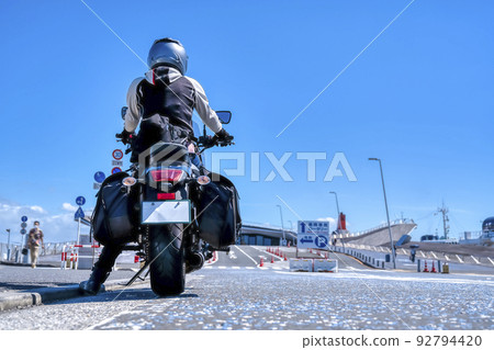Image cut of a female rider touring Yokohama on a large American motorcycle 92794420