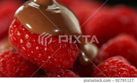 Freeze motion of pouring melted chocolate on raspberries. Freeze motion of pouring melted chocolate on raspberries. 92795127