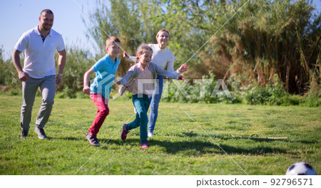 Children and parents run to the soccer sword in the summer in the park 92796571