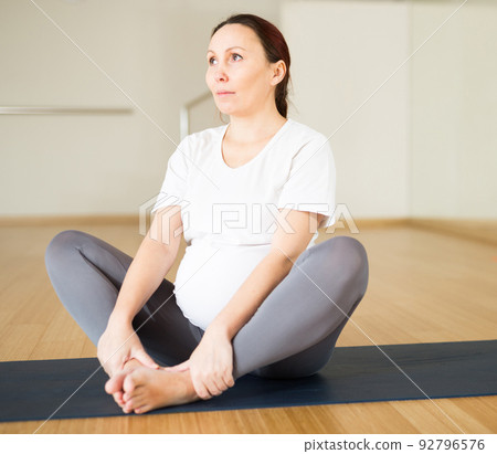Pregnant woman is engaged in yoga. Butterfly Pose or Baddha Konasana Pregnant woman is engaged in yoga. Butterfly Pose or Baddha Konasana 92796576