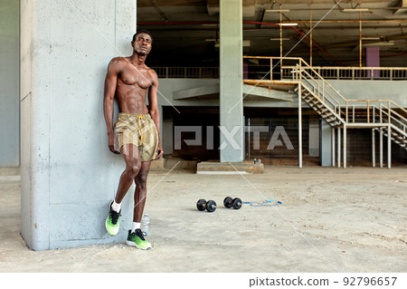 Handsome afro American sportman standing on the street while taking break after training. Black male having rest after workout 92796657