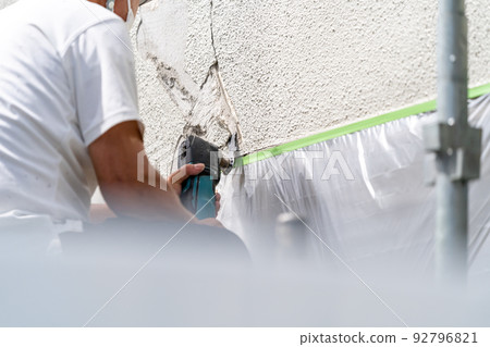 Construction site, exterior wall repair work, multi-tool Construction site, exterior wall repair work, multi-tool 92796821