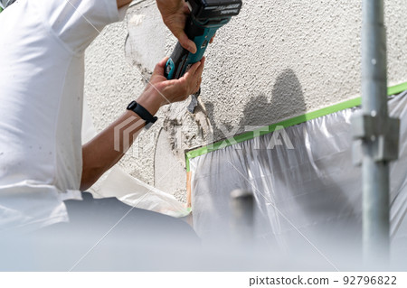 Construction site, exterior wall repair work, multi-tool Construction site, exterior wall repair work, multi-tool 92796822