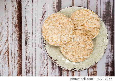 Round rice crackers on a plate on a rustic wooden table. Copy space. Healthy, natural food. Vegan food. 92797037