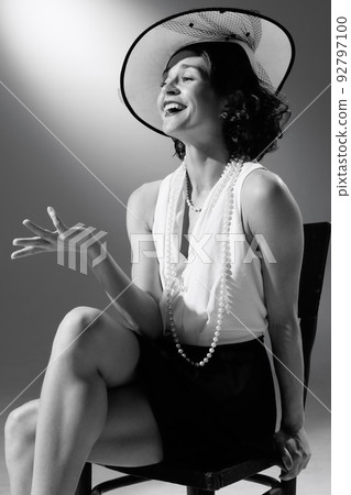 Portrait of beautiful woman in character of famous fashion designer posing in stylish classic suit. Black and white photography. Tender laugh 92797100