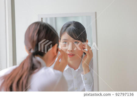 A woman who has something to worry about looking at the mirror 1 A woman who has something to worry about looking at the mirror 1 92797136