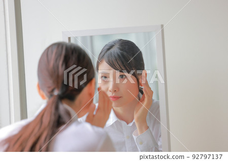 A woman who has something to worry about looking at the mirror 2 A woman who has something to worry about looking at the mirror 2 92797137