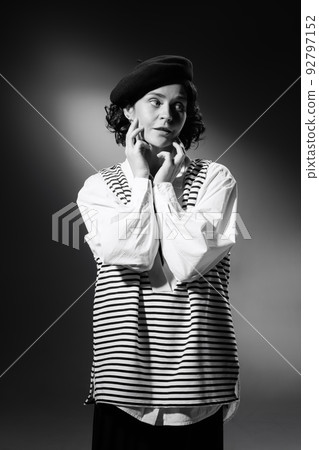 Portrait of elegant beautiful woman in stylish classical clothes, striped vest and hat posing. Black and white photography 92797152
