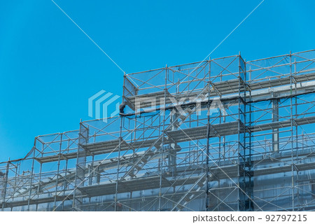 Scaffolding and mesh sheets at a construction site 92797215