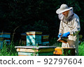 Beekeeper working collect honey. Beekeeping concept. Farmer wearing bee suit working with honeycomb in apiary. Organic farming. Copy-space. 92797604