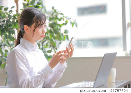 一個女人用尖嘴看智能手機 1 一個女人用尖嘴看智能手機 1 92797704