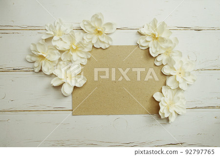 Empty paper craft with flower bouquet Top view on wooden background Empty paper craft with flower bouquet Top view on wooden background 92797765