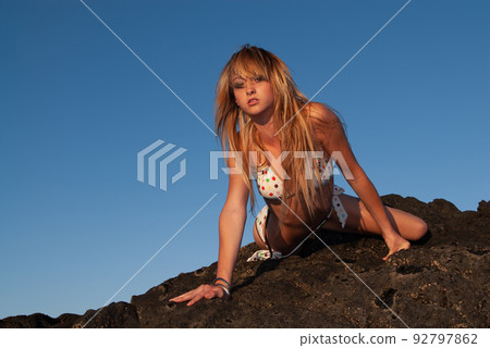 woman enjoying the sunset on the seashore woman enjoying the sunset on the seashore 92797862