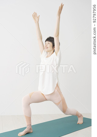 在家做瑜伽高弓步姿勢的高級女性 92797956