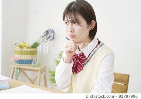 High school girl thinking while studying at home High school girl thinking while studying at home 92797990