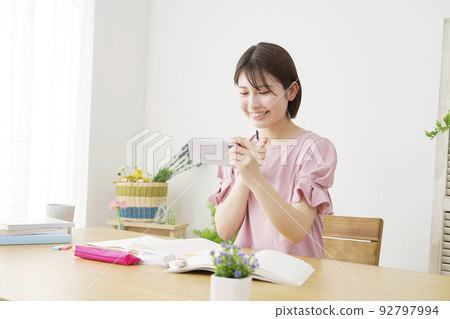 A woman studying at home using a learning app on her smartphone A woman studying at home using a learning app on her smartphone 92797994