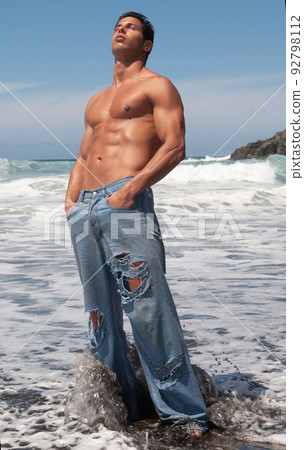 muscular man showing off his body under a sunny sky 92798112