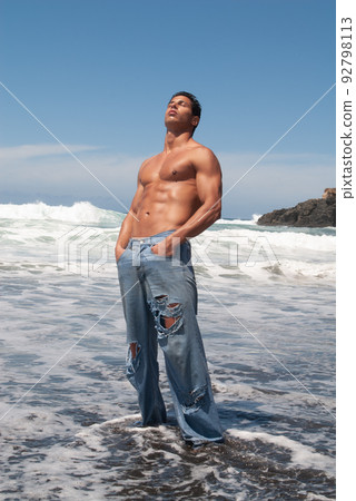 muscular man showing off his body under a sunny sky muscular man showing off his body under a sunny sky 92798113