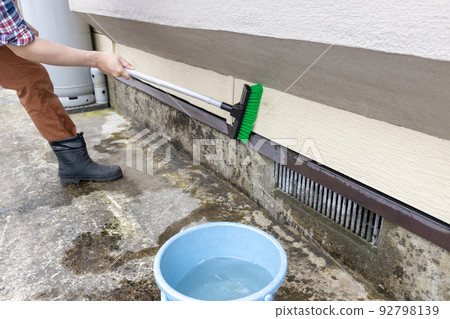 用甲板刷清洗房子的外牆 92798139