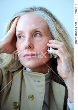 Mature female blond beauty talking on cellphone. 92798904