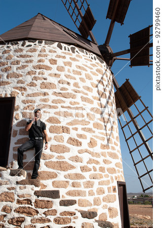 man leaning on the wall of a windmill man leaning on the wall of a windmill 92799460