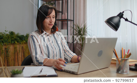 Young woman freelancer wearing headset, call center or support service operator helpline having talk 92799657