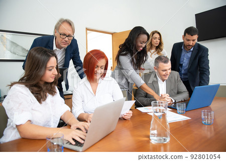 Business team of men and women in an office analyzing the evolution of the company 92801054