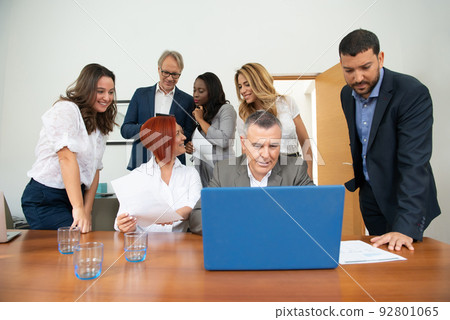 Business team of men and women in an office analyzing the evolution of the company 92801065