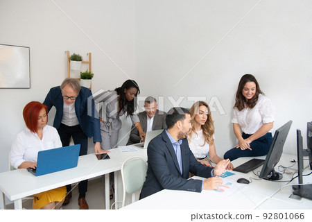 Business team of men and women in an office analyzing the evolution of the company 92801066