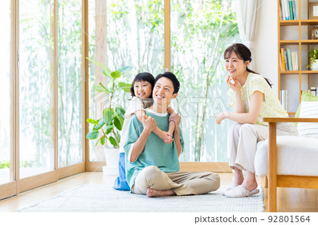 一個在客廳裡放鬆的年輕家庭 92801564