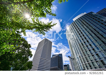 The view looking up at the buildings in Umeda, Osaka against the blue sky with the sun shining [Osaka scenery] 92802261